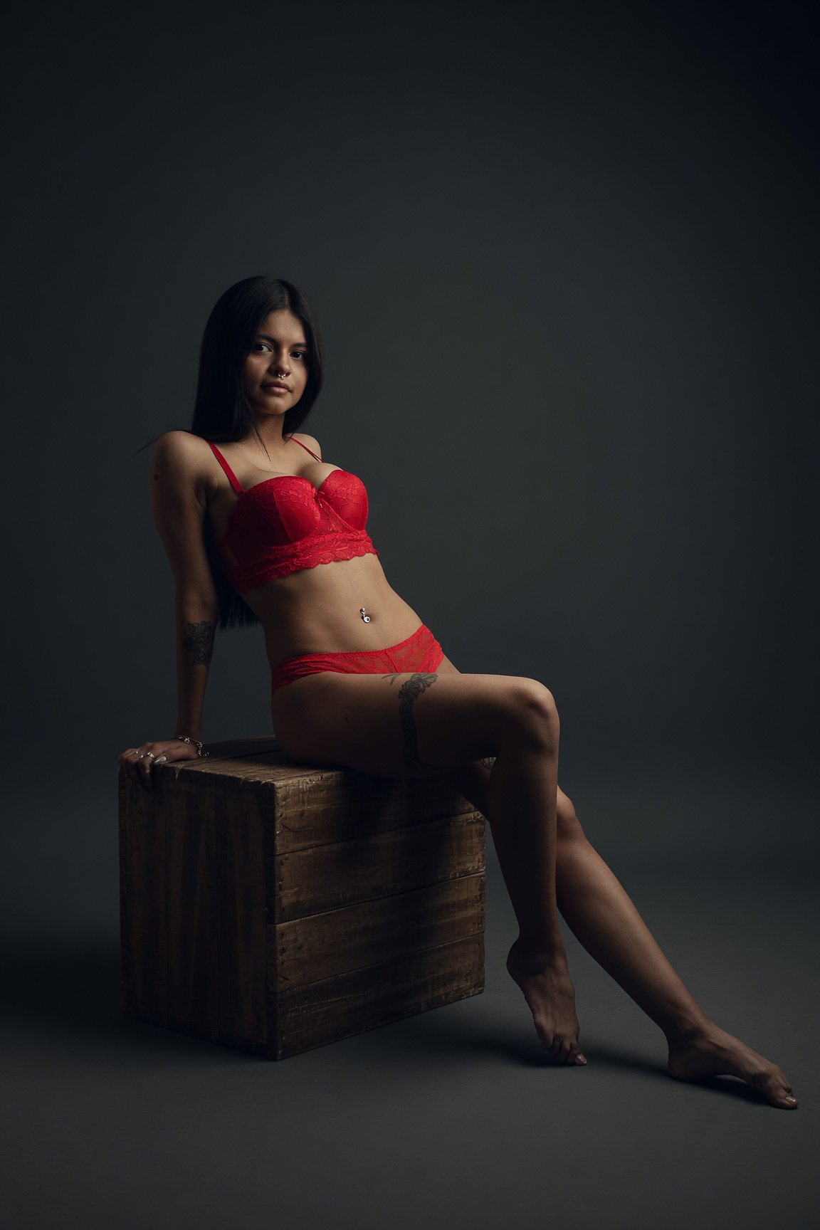 Lia Hancock seated in red lingerie