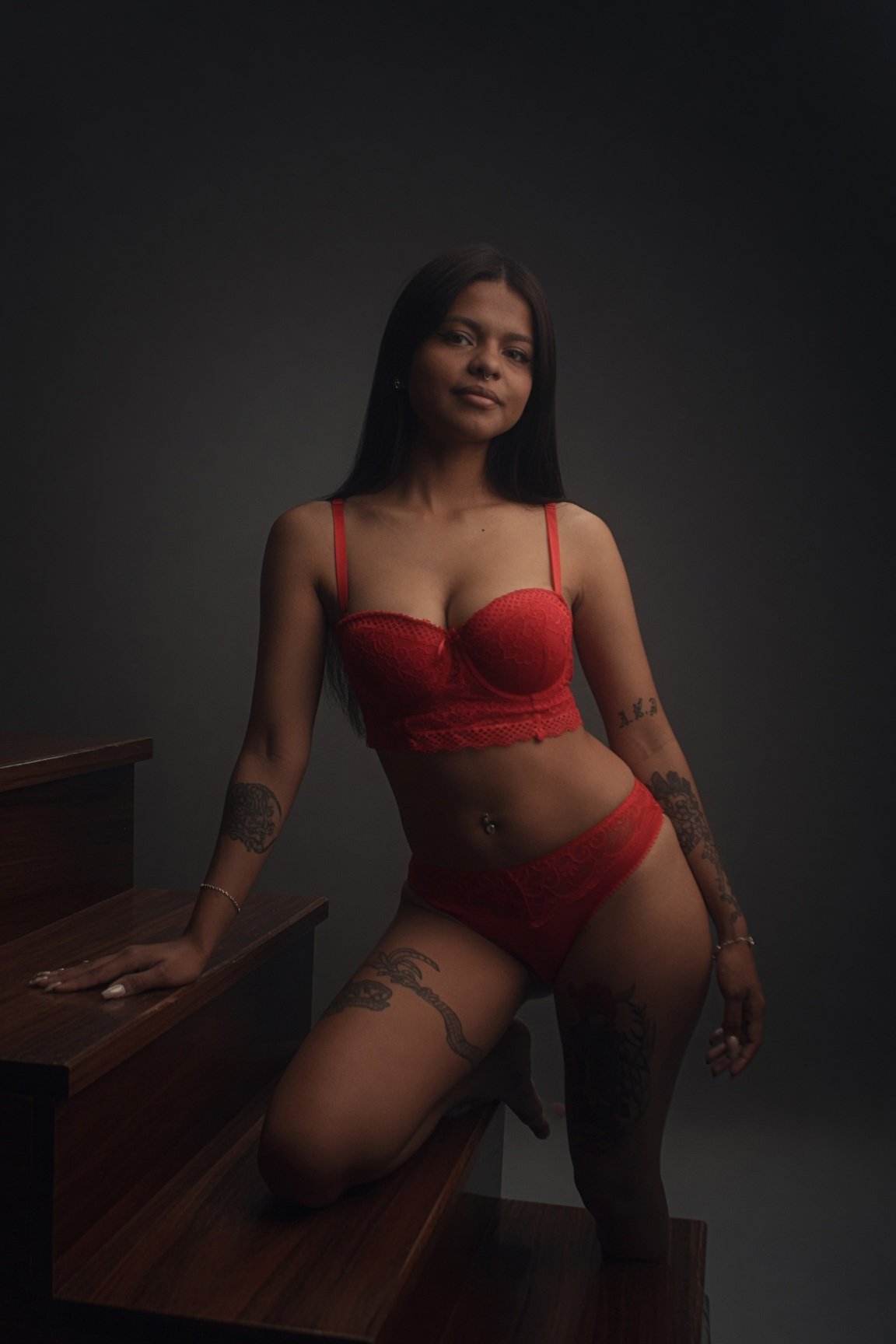 Lia Hancock in red lingerie by a wooden set